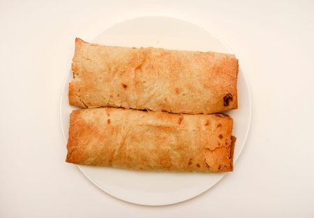 Meat shawarma on a white plate. Burritos with meat.