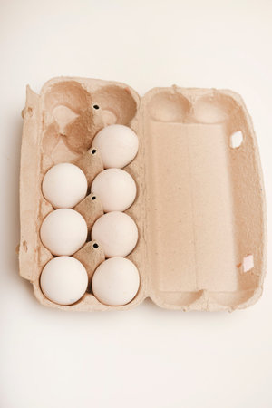 White eggs in a package. Chicken eggs on a white background.