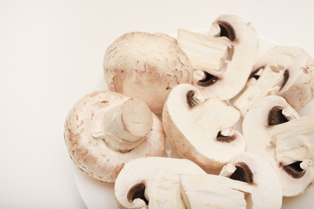Fresh champignons on a white plate. Mushrooms on a white background.の写真素材