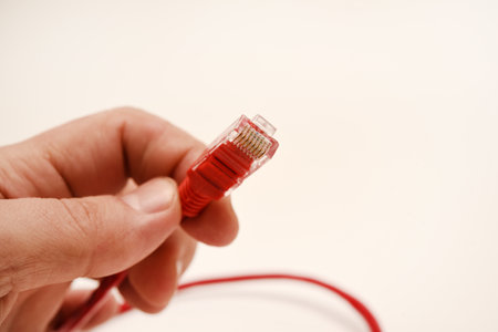 Red internet cable in hand. The RJ-45 connector.の写真素材