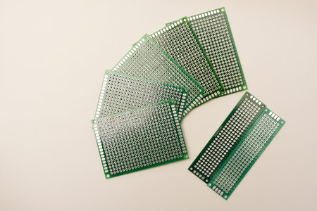 A green breadboard for electronics on a white background. Printed circuit boards for mounting...
