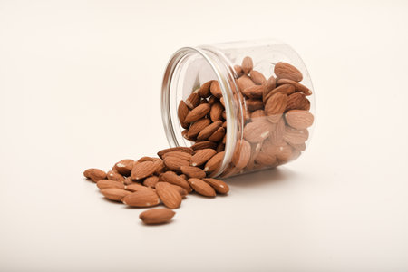 Whole almonds in a jar on a white background.の写真素材