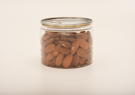 Whole almonds in a jar on a white background.の写真素材