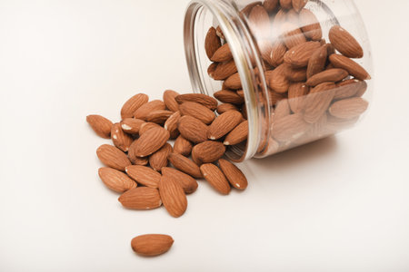 Whole almonds in a jar on a white background.の写真素材