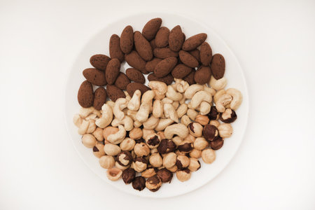 Cashews and hazelnuts almonds in cocoa in a jar on a white background. Nuts on a plate.の写真素材