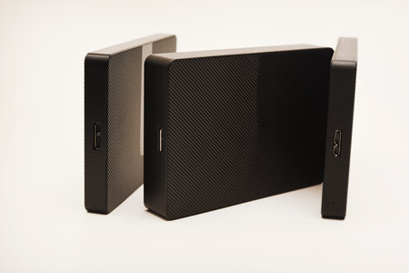 Hard drives on a white background. Modern data storage devices with USB wires.