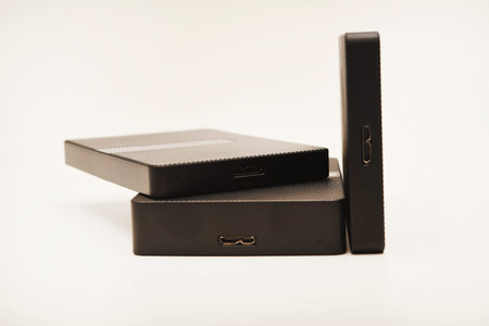 Hard drives on a white background. Modern data storage devices with USB wires.