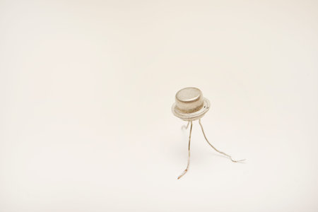 Metal transistors on a white background. A radio component with three outputs.