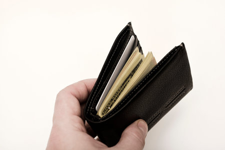 A black wallet with dollars on a white background. A wallet with money.