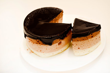 Coffee and milk cheesecake. A cake with cheese and chocolate on a plate.