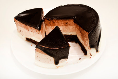 A cake with cheese and chocolate on a plate.の写真素材