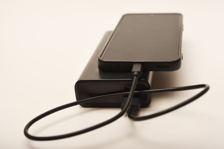 Charging a mobile phone from a powerbank. Charging the gadget.の写真素材