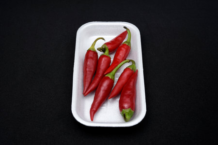 Red peppers on a white surface.の写真素材