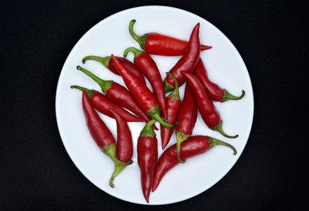 Red chili peppers on a white plate.の写真素材