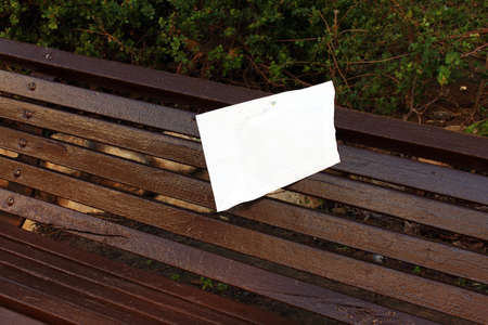 Freshly painted wooden bench on the sidewalkの写真素材