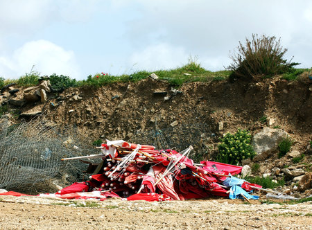 Old  beach umbrellas discarded to landfillの写真素材