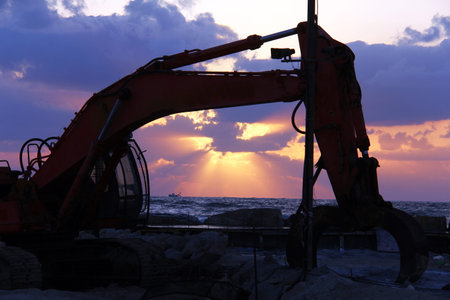  Large excavator on the sunset  over sea background
