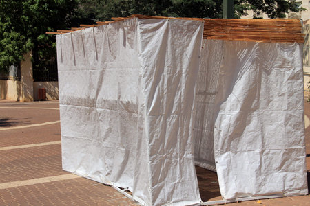 A sukkah is a temporary hut constructed for use during the week-long Jewish festival of Sukkot. It is topped with branches and often well decorated with autumnal, harvest or Judaic themes.の写真素材