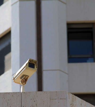 Surveillance camera mounted on the pole at the building roofの写真素材