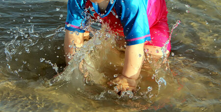 Baby playing with sea waterの写真素材