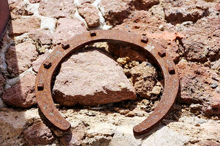 Rusty old horseshoe on stone road backgroundの写真素材