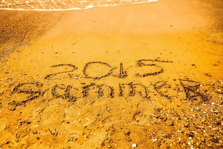 Inscription beach sand Summer 2015. Concept photo of summer travel and vacation.の写真素材