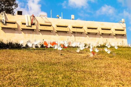 Many waving abstract hands signs or flags installed on a grassy lawn using the metal wireの写真素材