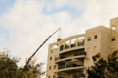 Delivery of the refrigerator in  original packaging to the penthouse via truck craneの写真素材