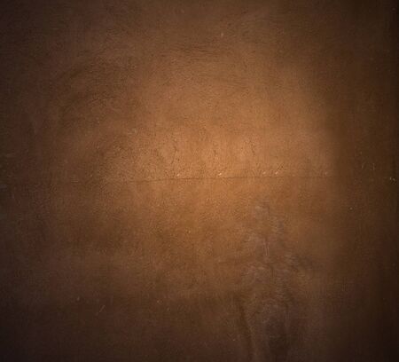 Brown painted  plaster pattern  background with spotlight and  place for your design or textの写真素材