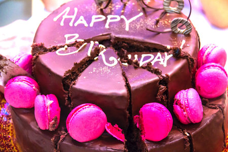 Cut into slices of birthday cake with the inscription Happy Birthday