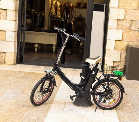 Electric bike near  open door of shopの写真素材