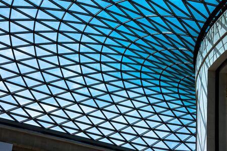 The British Museum glass ceiling. Museum was established in 1753, largely based on the collections of the physician and scientist Sir Hans Sloane. crown on top of the pillars on blue sky background. The Mall street. London. UKのeditorial素材