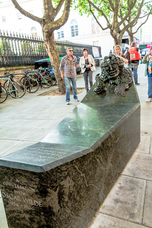 Unidentified people near Monument A Conversation With Oscar Wilde, located on Adelaide Street near Charing Cross, is a bench to be sat on, or a sculpture to be admired from a distance. crown on top of the pillars on blue sky background. The Mall street. Lのeditorial素材