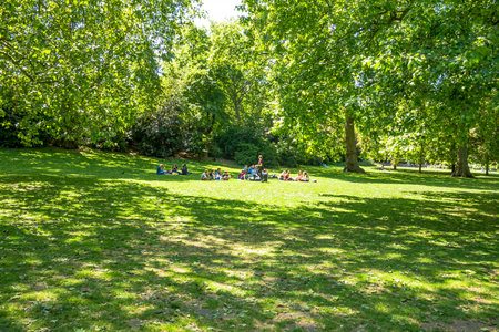 Unidentified young people is resting on the grass St. James's Park. London, UK