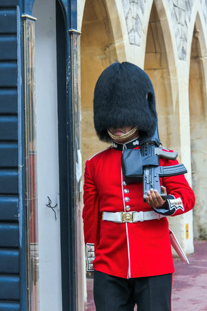Unidentified  British Queen's Guard in a traditional uniform marching on duty inside Windsor Castle. The Queen's Guard is the contingents of infantry and cavalry soldiers charged with guarding the official royal residences. UKのeditorial素材