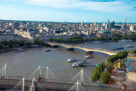 LONDON, UK - JUNE 6, 2015: Cityscape from London Eye with Haugerford Bridge over  the Thames and tourist pleasure boats in late afternoon liteのeditorial素材