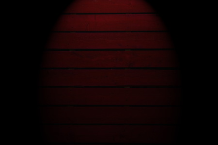 Old  dark red painted wooden wall  with spotlight- texture or backgroundの写真素材