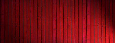 Old  dark red painted wooden wall  with spotlight- texture or background