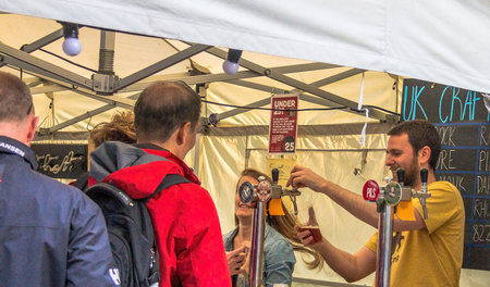LONDON, UK - JUNE 6, 2015: Unidentified people standing in line  for draft craft beer  near  pub on...