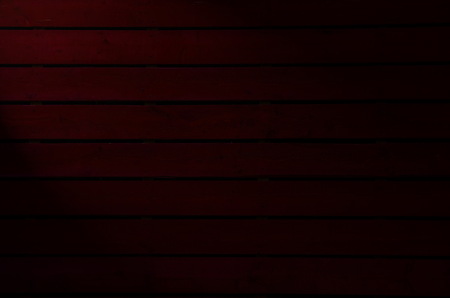 Old  dark red painted wooden wall  with spotlight- texture or backgroundの写真素材