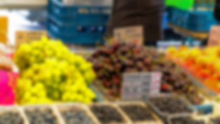 Blurred view of green grapes, cherry and blueberry at city fruit and vegetable market.の写真素材