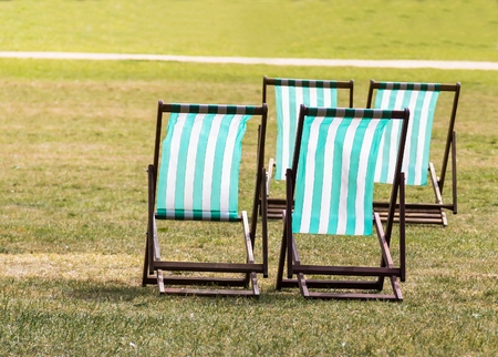 Four deckchairs for hire in Hyde Park. Westminster. London. England.の写真素材