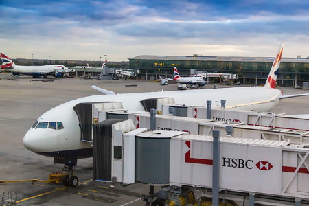 LONDON, UK - JUNE 9, 2015: Loading passengers in the Boeing 777 near one of the terminals of Heathrow Airport London's biggest airportのeditorial素材