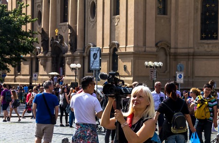 Prague, Czech Republic -July 23,2017: Blond woman is engaged in video shooting at Old Town Square. It's a historic square in the Old Town quarter of Prague, popular with touristsのeditorial素材