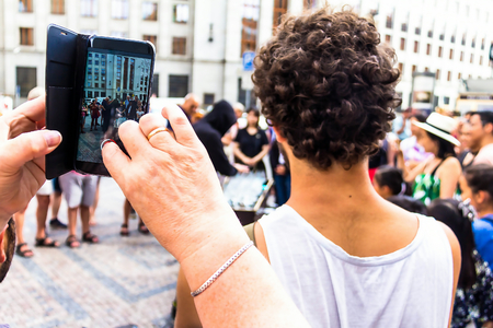 Prague, Czech Republic -July 23,2017: A young man in a black hood playing music on wine glasses water filledのeditorial素材