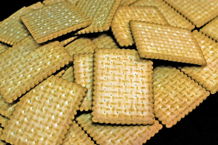 A pile of cookies on black background. Selective focus