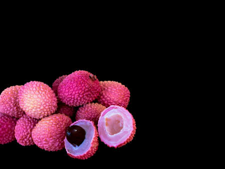Lychee- small rounded fruit with sweet white scented flesh, a large central stone, and a thin rough skin- on black background. Selective focusの写真素材