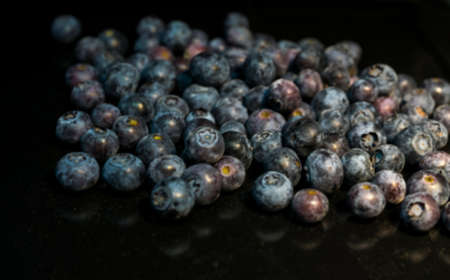 Blueberries scattered on a dark background. Blurred viewの写真素材