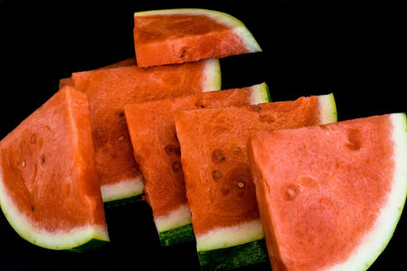 Slices of red ripe sweet watermelon on black background, closeup , selective focus