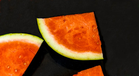 Slices of red ripe sweet watermelon on black background, closeup , selective focus